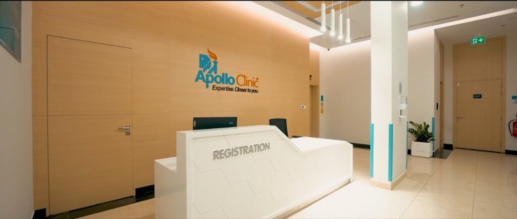 Modern clinic reception area with 'Apollo Clinic' logo and registration desk.